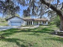 Charming home featuring lush lawn and mature trees at 6602 Winding Brook Dr, New Port Richey, FL 34655