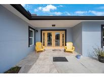 Charming front entrance with double doors and welcoming yellow Adirondack chairs at 965 S Florida Ave, Tarpon Springs, FL 34689