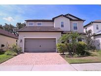 Charming two-story home featuring a paved driveway, two-car garage, and well-manicured landscaping at 10431 Alcon Blue Dr, Riverview, FL 33578