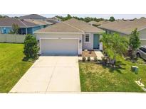 Charming single-story home featuring a manicured lawn, a two-car garage and a lovely, covered front entryway at 10945 High Noon Trl, Parrish, FL 34219