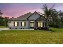 Charming single-story home featuring stone accents, a well-manicured lawn, and a welcoming entrance at 13334 Oldenburg Dr, Hudson, FL 34667