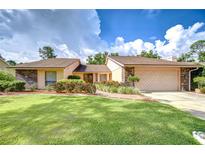 Well-manicured lawn and mature landscaping complement this charming single-Gathering home at 13903 Wolcott Dr, Tampa, FL 33624