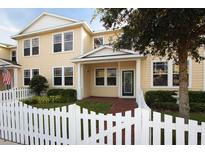 Charming two-story home with yellow siding, white picket fence, and well-maintained landscaping at 16137 Churchview Dr, Lithia, FL 33547