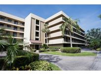 Modern condominium building featuring a well-maintained garden and mature palm trees at 1846 Golfview Dr # 1846, Tarpon Springs, FL 34689