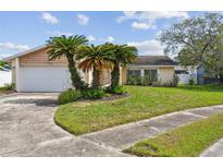 Charming single-story home with palm trees, lush lawn, and a two-car garage at 1944 Hastings Ln, Clearwater, FL 33763