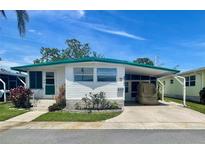 Charming mobile home with covered parking and a well-maintained front yard at 34041 Azalea N Dr, Pinellas Park, FL 33781