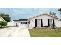 Charming single-story home with a white exterior, black shutters, and a well-maintained front yard at 6508 Lenore Dr, Tampa, FL 33634