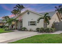 Charming single-story home featuring a well-manicured lawn, palm trees, and a welcoming facade at 6521 69Th N Ave, Pinellas Park, FL 33781
