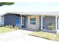 Charming single-story home featuring a textured exterior, landscaped yard, and a bright blue front door at 6527 S West Shore Cir, Tampa, FL 33616