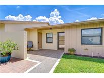 Inviting front entrance with a cozy seating area, decorative plants, and well-maintained landscaping at 6550 Teak Ct, Zephyrhills, FL 33542