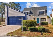 Charming two-story home with a blue garage door and turquoise front door at 7318 Bellows Falls Ln, Hudson, FL 34667
