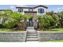 Inviting home featuring stone accents, beautiful landscaping with palm trees and an elevated stone staircase at 13311 Dorado Shores Ave, Riverview, FL 33579
