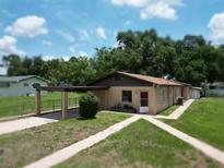 Charming single-story home with a covered carport, walkway, and simple landscaping at 14312 1St St, Dade City, FL 33525