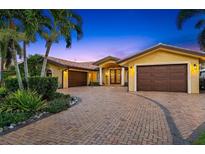 Stunning exterior of a yellow stucco home with a tile roof and a circular driveway lined with palm trees and manicured landscaping at 1931 Kentucky Ne Ave, St Petersburg, FL 33703