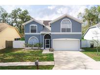 Charming two-story home with a well-maintained lawn and an attached two-car garage at 2318 Kenwick Dr, Valrico, FL 33596