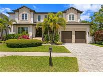Stunning two-story home featuring stone accents, a paved driveway, and lush landscaping with palm trees at 4807 W Longfellow Ave, Tampa, FL 33629