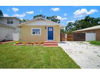 Charming bungalow with a blue front door, fresh landscaping, and off street parking at 6419 S Englewood Ave, Tampa, FL 33611