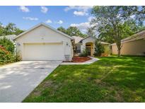 Inviting single-story home featuring a two-car garage, landscaped front yard, and charming curb appeal at 6918 Potomac Cir, Riverview, FL 33578