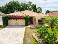 Charming one-story home featuring a tile roof, stone accents, and a landscaped front yard at 6928 Cozumel Ct, Land O Lakes, FL 34637