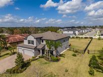 Stunning two-story home featuring manicured landscaping, a three-car garage, and a sprawling green lawn at 9814 Palazzo St, Seffner, FL 33584