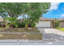 Charming single-story home featuring a two-car garage and mature landscaping at 11816 Cedarfield Dr, Riverview, FL 33579
