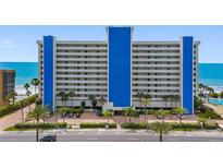 Bright and airy exterior shot of the condo building overlooking tropical landscaping and the ocean at 14950 Gulf Blvd # 905, Madeira Beach, FL 33708