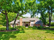 Stately brick home with mature trees, lush landscaping, and a well-manicured lawn at 16502 Millan De Avila, Tampa, FL 33613