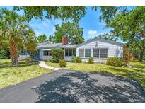 Charming single-story home with a well-manicured lawn, a brick chimney, and a sunny front yard at 601 75Th St N, St Petersburg, FL 33710