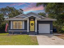 Charming home featuring a yellow front door, an attached garage, and an American flag at 642 14Th S Ave, St Petersburg, FL 33701