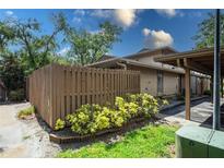 Home exterior featuring wood fence, green landscaping, and reserved parking at 802 Antler Ct, Brandon, FL 33511