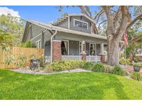 Charming gray craftsman-style home with inviting front porch, brick accents, and lush green lawn at 1005 Main St, Safety Harbor, FL 34695