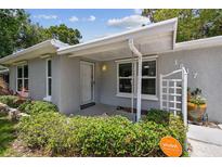 Inviting front entrance of gray home, featuring well-maintained landscaping and a Vivint SmartHome security sign at 1817 West Dr, Clearwater, FL 33755