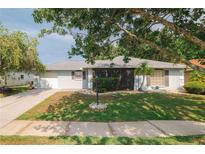 Charming single-story home featuring a well-maintained lawn and a welcoming, covered entryway at 1949 Tampa Bay Dr, Wesley Chapel, FL 33543