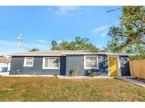 Charming single-story home with a well-maintained lawn and a bright yellow front door at 243 45Th N St, St Petersburg, FL 33713