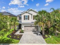 Lovely two-story house with a two-car garage, solar panels, palm trees, and a well-maintained lawn situated in a friendly neighborhood at 4177 Beeswax Ln, Land O Lakes, FL 34638
