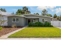 Charming single-story home featuring a well-manicured lawn and lush landscaping at 433 Pineapple St, Tarpon Springs, FL 34689