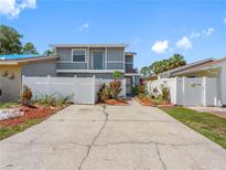 Well-maintained two-story home featuring a fenced yard, colorful landscaping, and a spacious driveway at 4813 Glenaire Ct, Tampa, FL 33624