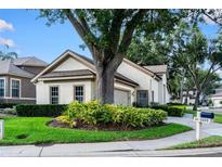 Charming home with a well-manicured lawn, a mature tree, and tasteful landscaping at 5205 Fairway One Dr, Valrico, FL 33596