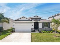 Charming single-story home featuring stone accents, a two-car garage, and well-maintained landscaping at 5411 Thistle Field Ct, Wesley Chapel, FL 33545