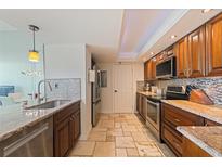 Well-equipped kitchen featuring stainless steel appliances, granite countertops, and beautiful tile backsplash at 6265 Sun Blvd # 1203, St Petersburg, FL 33715