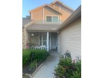 Inviting two-story home with a well-maintained lawn and landscaped front walk way, offering a warm and welcoming curb appeal at 6520 Thicket Trl, New Port Richey, FL 34653