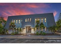 Inviting condominium exterior featuring tropical landscaping, and a well-maintained façade at sunset at 704 Lyndhurst St # 624, Dunedin, FL 34698
