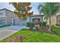 Charming single-story home featuring a well-manicured lawn and colorful landscaping at 9423 Lemon Drop Loop, Sun City Center, FL 33573