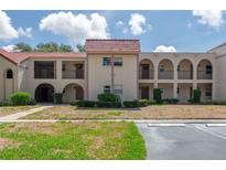 Charming condo complex with red tile roof, arched balconies, and neat landscaping at 9700 Starkey Rd # 325, Seminole, FL 33777