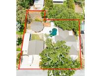 An aerial view showcasing a private backyard with a pool, spa, and expansive lot outlined in red at 11988 117Th St, Seminole, FL 33778