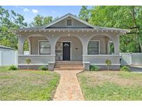 Charming bungalow showcasing a covered porch, brick walkway, and well-maintained lawn at 1203 E New Orleans Ave, Tampa, FL 33603