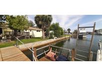 Waterfront canal view featuring lush landscaping, a private dock, and boat-friendly access for serene coastal living at 13815 San Juan Ave, Hudson, FL 34667