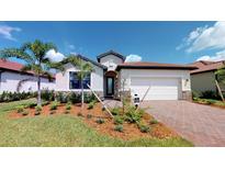 Stunning single-Gathering home with lush landscaping, barrel tile roof, and charming curb appeal in a desirable community at 15021 Oxford Grey Dr, Lakewood Ranch, FL 34211