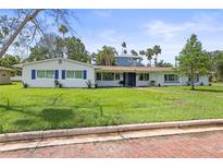 Charming single-story home with manicured lawn, blue shutters, and brick-paved street at 1794 Santa Barbara Dr, Dunedin, FL 34698