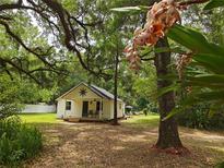 Charming home featuring a covered porch and lovely landscaped front yard in a verdant setting at 18452 Fort Dade Ave, Brooksville, FL 34601